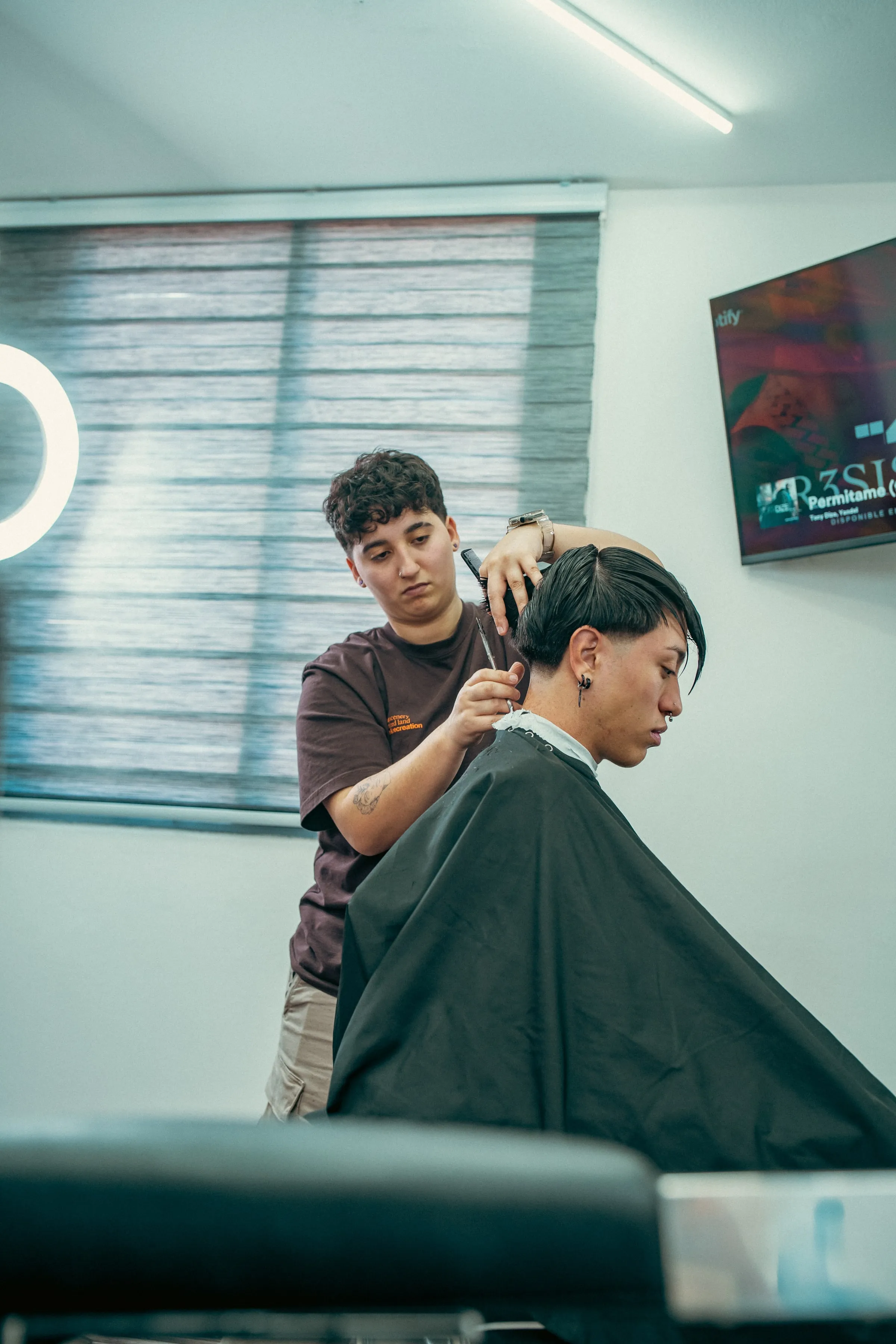 Ina cortando el pelo a un cliente en el local de Fade Studio